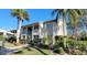 Inviting condominium exterior boasts lush landscaping and a well-maintained two-story building with palm trees at 7151 Wood Creek Dr # 205, Sarasota, FL 34231