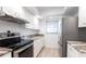 Efficient kitchen featuring stainless steel appliances, white cabinets, and modern countertops at 7151 Wood Creek Dr # 205, Sarasota, FL 34231