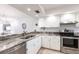 Updated kitchen with stainless steel appliances, stone countertops, and white cabinetry at 7151 Wood Creek Dr # 205, Sarasota, FL 34231