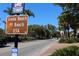 Siesta Beach sign along a road with palms and trees on a bright sunny day at 7151 Wood Creek Dr # 205, Sarasota, FL 34231