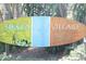 A Siesta Key Village sign is surrounded by lush green foliage and vegetation at 7151 Wood Creek Dr # 205, Sarasota, FL 34231