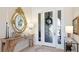 Entryway with decorative mirror, tiled floors, an ornate table and a glass accented front door at 7211 Prestbury Cir, Lakewood Ranch, FL 34202
