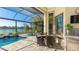 Screened patio with seating area, outdoor kitchen, pool, and lake view at 7211 Prestbury Cir, Lakewood Ranch, FL 34202