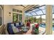 Covered patio with seating area, pool, and lake view at 7211 Prestbury Cir, Lakewood Ranch, FL 34202
