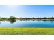 Scenic view of a tranquil pond surrounded by lush greenery and beautiful homes at 7211 Prestbury Cir, Lakewood Ranch, FL 34202