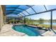 Beautiful screened pool with waterfall features and view of the lake at 7211 Prestbury Cir, Lakewood Ranch, FL 34202
