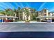 Beautiful condo building with covered parking surrounded by manicured landscaping and tall palm trees at 7803 Grand Estuary Trl # 303, Bradenton, FL 34212