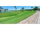 Picturesque golf course view with a golfer on the green, surrounded by lush landscaping and serene water features at 7803 Grand Estuary Trl # 303, Bradenton, FL 34212