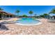Stunning resort-style pool surrounded by ample lounge chairs and palm trees under a clear sky at 7803 Grand Estuary Trl # 303, Bradenton, FL 34212