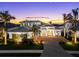 Elegant two-story home boasts lush landscaping, paver driveway, and a serene sunset backdrop at 8281 Redonda Loop, Lakewood Ranch, FL 34202