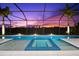 Sparkling pool and spa with tiled accents, surrounded by a screened enclosure with a beautiful sunset view at 8281 Redonda Loop, Lakewood Ranch, FL 34202
