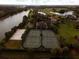 Aerial view of community tennis and sports courts, with green trees, a lake and other amenities at 8847 Colonels Ct, Sarasota, FL 34240