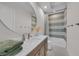 Modern bathroom with a vanity, a round mirror, and a shower/tub combo with stylish tiling at 8847 Colonels Ct, Sarasota, FL 34240