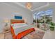 Bright bedroom with views of the pool and golf course features a statement chandelier and neutral decor at 8847 Colonels Ct, Sarasota, FL 34240