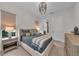 Cozy bedroom with a modern chandelier and view to the ensuite bath at 8847 Colonels Ct, Sarasota, FL 34240