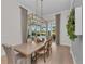 Bright dining room with a long table, accent lighting, and sliding glass doors to the pool at 8847 Colonels Ct, Sarasota, FL 34240