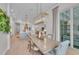 Open-concept dining room featuring a statement light fixture and sliding glass doors to outdoor living space at 8847 Colonels Ct, Sarasota, FL 34240