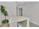 Bright flex room with a central workspace table, light wood floors, and a large indoor plant at 8847 Colonels Ct, Sarasota, FL 34240