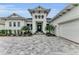 Welcoming home entrance with manicured landscaping and paver driveway leading to garage at 8847 Colonels Ct, Sarasota, FL 34240