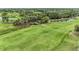 Overhead view of a green golf course with trees, a bridge, and ponds at 8847 Colonels Ct, Sarasota, FL 34240
