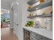 Hallway featuring a stylish bar area with floating shelves, under-counter refrigerator, and coffee maker at 8847 Colonels Ct, Sarasota, FL 34240
