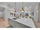 Open concept kitchen with gray island, bar seating, and views into a living room with fireplace at 8847 Colonels Ct, Sarasota, FL 34240