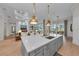 Kitchen island with bar seating and sink, open to living spaces and outdoor views at 8847 Colonels Ct, Sarasota, FL 34240