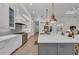 Bright kitchen with gray island, white cabinets, stainless steel appliances, and stylish pendant lights at 8847 Colonels Ct, Sarasota, FL 34240