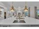 Kitchen island with bar seating and sink, pendant lighting and views of an elegant living space at 8847 Colonels Ct, Sarasota, FL 34240