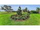 Manicured landscaping in circular design around trees, foliage, and flowering bushes at 8847 Colonels Ct, Sarasota, FL 34240