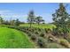 Lush landscaping with manicured garden beds and view of open green space at 8847 Colonels Ct, Sarasota, FL 34240