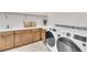 Well-organized laundry room with front loading machines and ample counter space at 8847 Colonels Ct, Sarasota, FL 34240