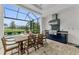 Outdoor kitchen with built-in grill and bar top seating overlooking the pool and golf course at 8847 Colonels Ct, Sarasota, FL 34240