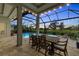 Outdoor living with dining by the pool, spa, and golf course in the background at twilight at 8847 Colonels Ct, Sarasota, FL 34240