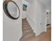 Light and bright staircase with carpet runner, complemented by unique mirror decor and hardwood floors at 8847 Colonels Ct, Sarasota, FL 34240