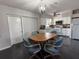 Bright kitchen and dining area features white cabinetry, modern lighting, and stainless steel appliances at 907 Temple Ave, Bradenton, FL 34207