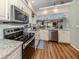 An open concept kitchen featuring stainless steel appliances, white cabinets and granite countertops at 926 Capri Isles Blvd # 228, Venice, FL 34292