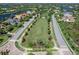 Aerial view of neighborhood, landscaping, and streets. Homes surround a central park and other lakes at 7921 Waterton Ln, Lakewood Ranch, FL 34202