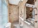 Luxurious walk-in shower with premium fixtures and luxurious travertine tile throughout at 7921 Waterton Ln, Lakewood Ranch, FL 34202