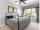 Cozy bedroom with a wrought iron bed frame and ample natural light from the large window at 7921 Waterton Ln, Lakewood Ranch, FL 34202