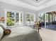 Serene bedroom with large windows showcasing tranquil lake views and a screened patio at 7921 Waterton Ln, Lakewood Ranch, FL 34202