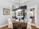 Elegant dining room with glass table, stylish chairs, and pool view through bay window at 7921 Waterton Ln, Lakewood Ranch, FL 34202