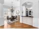 Elegant dining area with hardwood floors, chandelier, and window views, adjacent to the kitchen at 7921 Waterton Ln, Lakewood Ranch, FL 34202