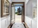 Elegant foyer with decorative tile, leading to a lush landscape view through the home's ornate front door at 7921 Waterton Ln, Lakewood Ranch, FL 34202