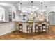 Gourmet kitchen featuring a large island with bar seating, hardwood floors, and pendant lighting at 7921 Waterton Ln, Lakewood Ranch, FL 34202