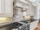 Close up of the gourmet kitchen with a stainless steel range and custom cabinets at 7921 Waterton Ln, Lakewood Ranch, FL 34202