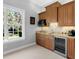 Charming kitchenette boasts custom wood cabinets, granite countertops, and stainless steel refrigerator at 7921 Waterton Ln, Lakewood Ranch, FL 34202