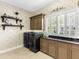 Well-appointed laundry room with modern washer and dryer, custom cabinetry, and stylish decor accents at 7921 Waterton Ln, Lakewood Ranch, FL 34202