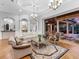 Spacious living room with elegant columns, seamless indoor/outdoor flow to the covered patio, and hardwood floors at 7921 Waterton Ln, Lakewood Ranch, FL 34202