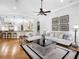 Elegant living room with seating, hardwood floors, and an open view to the kitchen and dining area at 7921 Waterton Ln, Lakewood Ranch, FL 34202